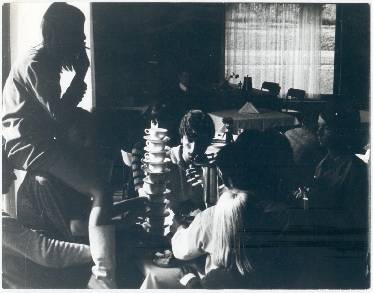 Die Geschichte der Tischbenutzung an einem Nachmittag vergegenständlicht sich zu einem Pyramidenbau übereinandergeschichteter Sitzender, Kaffeetassen, Bestecke, Kannen, Teller usw., Bild: Aus: "Das Seminar" - ein Film von Bazon Brock und Werner Nekes, 1967. © Werner Nekes.